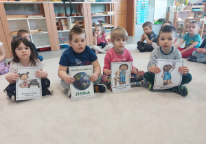 dzieci pokazują plansze związane z dbaniem o Ziemię